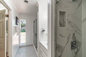 Bathtub, hair dryer, towels, shampoo
