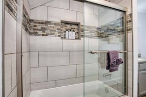 Bathtub, hair dryer, towels, shampoo