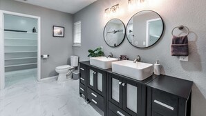 A modern bathroom with two sinks, a toilet, and a shower area. - Sleep 29 - Oceanfront Retreat 2 Homes for 29-Guests! (Corpus Christi)