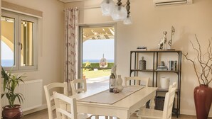 Un coin repas avec une table et des chaises, une bibliothèque et une plante en pot.