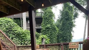 An outdoor wooden deck with picnic tables and a rocking chair. - Blue Sky Relaxation Retreat! (Gatlinburg)
