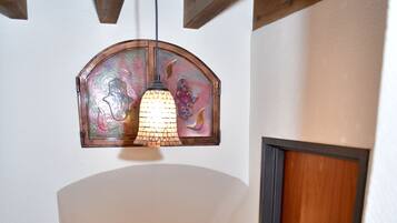A staircase with a wooden handrail, a door with a dark frame, and a wall-mounted light fixture.