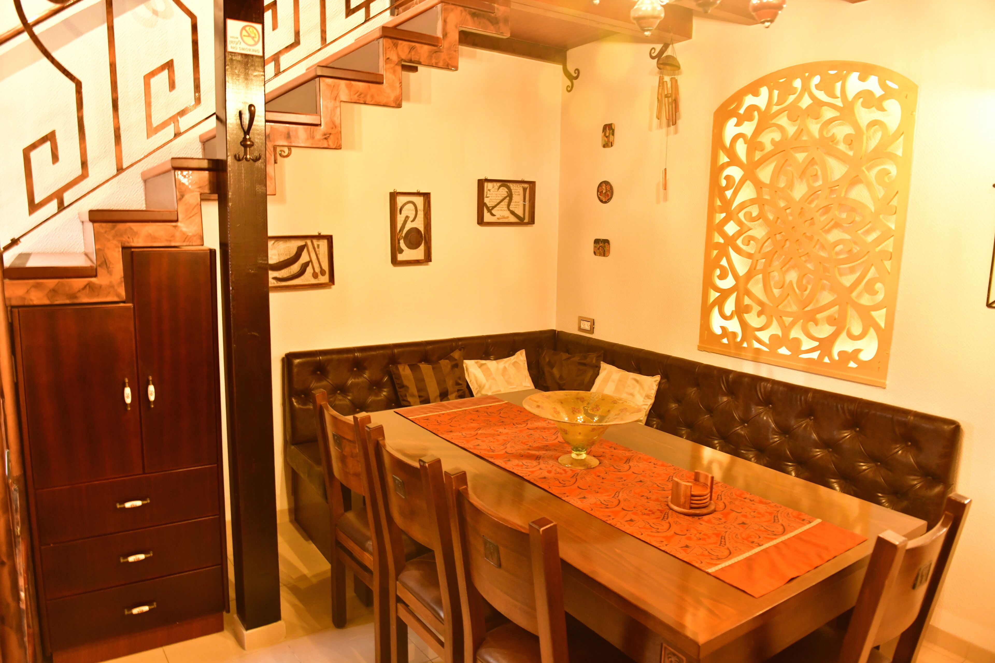 Un comedor con una mesa de madera, sillas y un adorno en la pared.