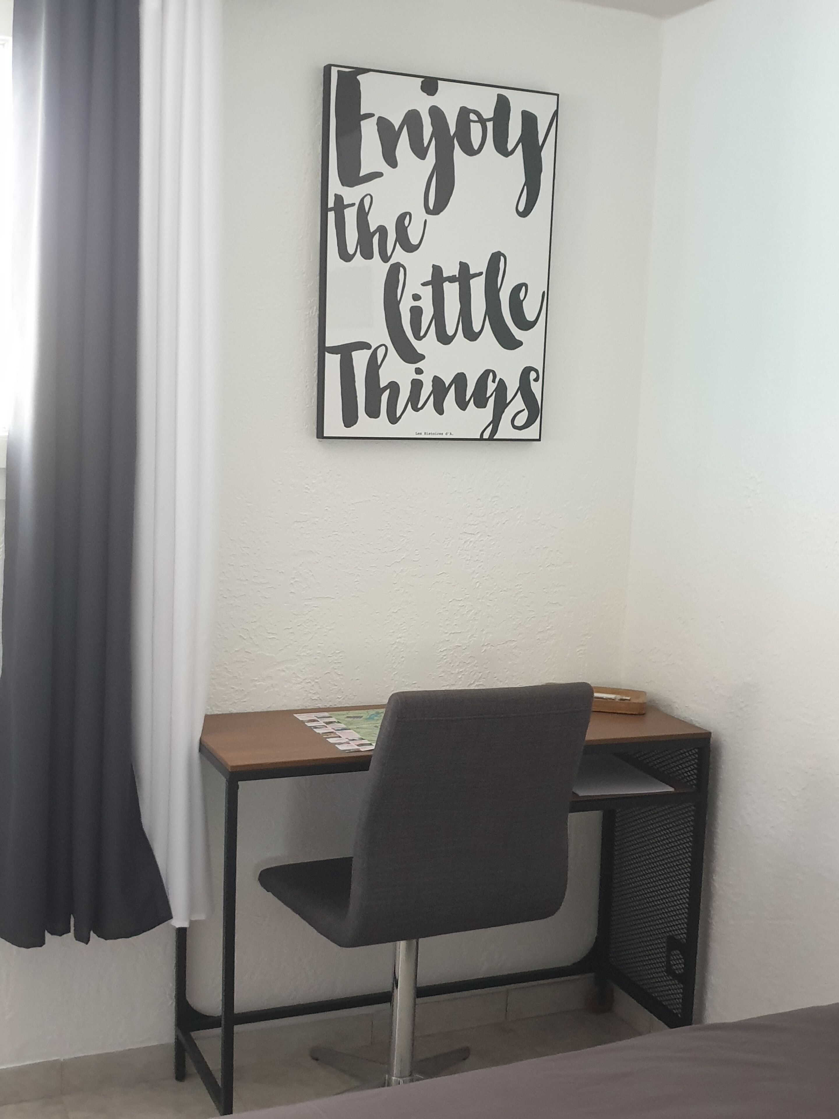 Une pièce comprenant un bureau, une chaise et une citation inspirante affichée sur le mur.