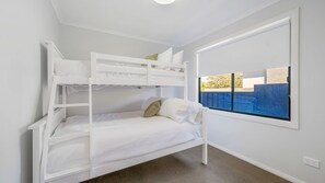 A bunk bed room with a window providing a view of the outside.
