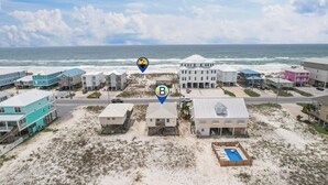 Una zona residenziale sulla costa, con proprietà fronte spiaggia, tra cui case con balconi e una piscina.