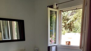 A bedroom with a bed, a window, and a radiator.
