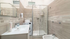 Ein modernes Badezimmer mit Duschkabine aus Glas, Waschbecken, Bidet und Toilette.