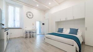 Ein Schlafzimmer mit einem Bett, Nachttischen und einer Wanduhr.