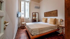 Une chambre à coucher avec un lit en bois, une chaise, une petite table et une fenêtre donnant sur un paysage agréable.