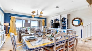 A dining area with a table set for four, a sofa, and a television in the background. - Ocean Dream Villa | Beachfront Indian Rocks Beach (Indian Rocks Beach)