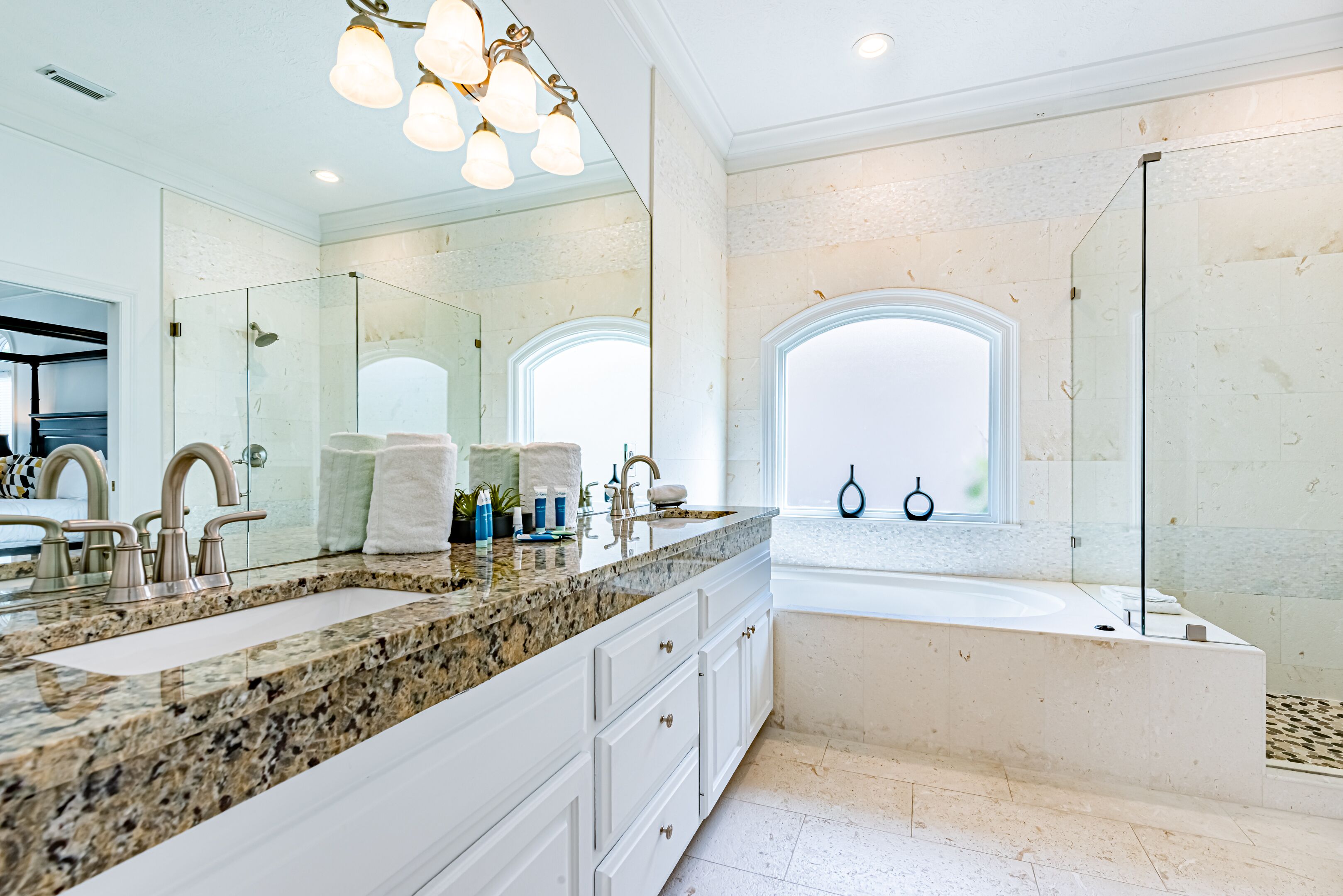 A modern bathroom with a large vanity, double sinks, and a bathtub.