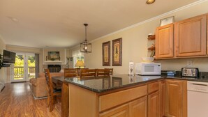 A spacious kitchen with wooden cabinets, a central island, a microwave, and a toaster. - Woodbridge Inn Retreat: Perfect Frisco Location (Frisco)