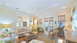 A spacious living room with a sofa, chairs, a coffee table, and a dining area with a table and chairs. - Large 1BD  Stand Alone Home in Seaside w/Tower & Porches + 2 Adult Bikes! (Santa Rosa Beach Fl)