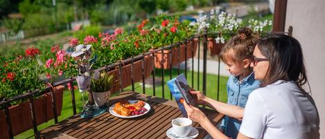 A wooden table with a plate of food, a cup of coffee, and a book.
