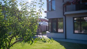 Ein modernes, zweistöckiges Gebäude mit großen Fenstern und einem Balkon mit Blumentöpfen.