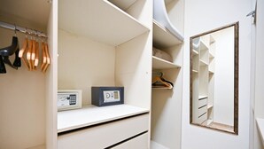 Un vestidor amplio con espacio para colgar ropa, una radio y un espejo.