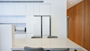 A modern kitchen with white cabinets, a double-door refrigerator, and a marble countertop. - Sweet Home 3BR near the sea by HolyGuest (Tel Aviv-Yafo)
