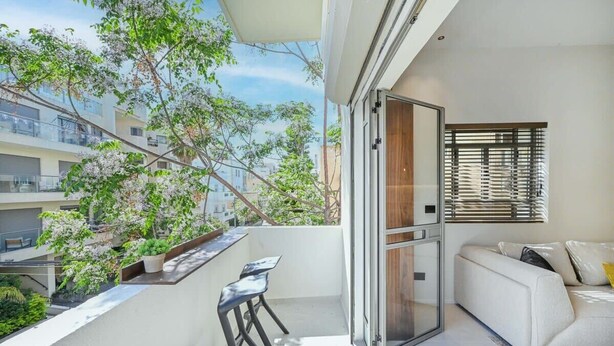 Un appartement moderne doté d’un balcon, d’un canapé et d’un coin repas.