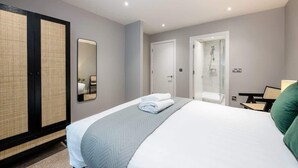 A hotel room with a bed, a large mirror, a wardrobe, and a shower area. - Host & Stay | Henry Street Chambers (Liverpool)