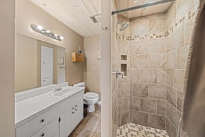 Ein Badezimmer mit Dusche, Waschbecken und Toilette.