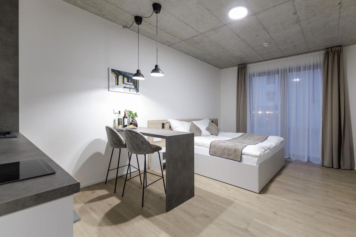 Une chambre moderne avec un lit, un bureau et deux chaises.