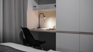 A modern bedroom with a bed, a desk, and a chair.