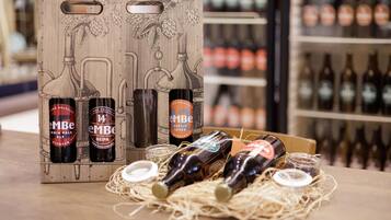 A wooden box with bottles of 'EMBE' beer, a bottle of 'India Pale Ale', and a bottle of 'Neipa'.