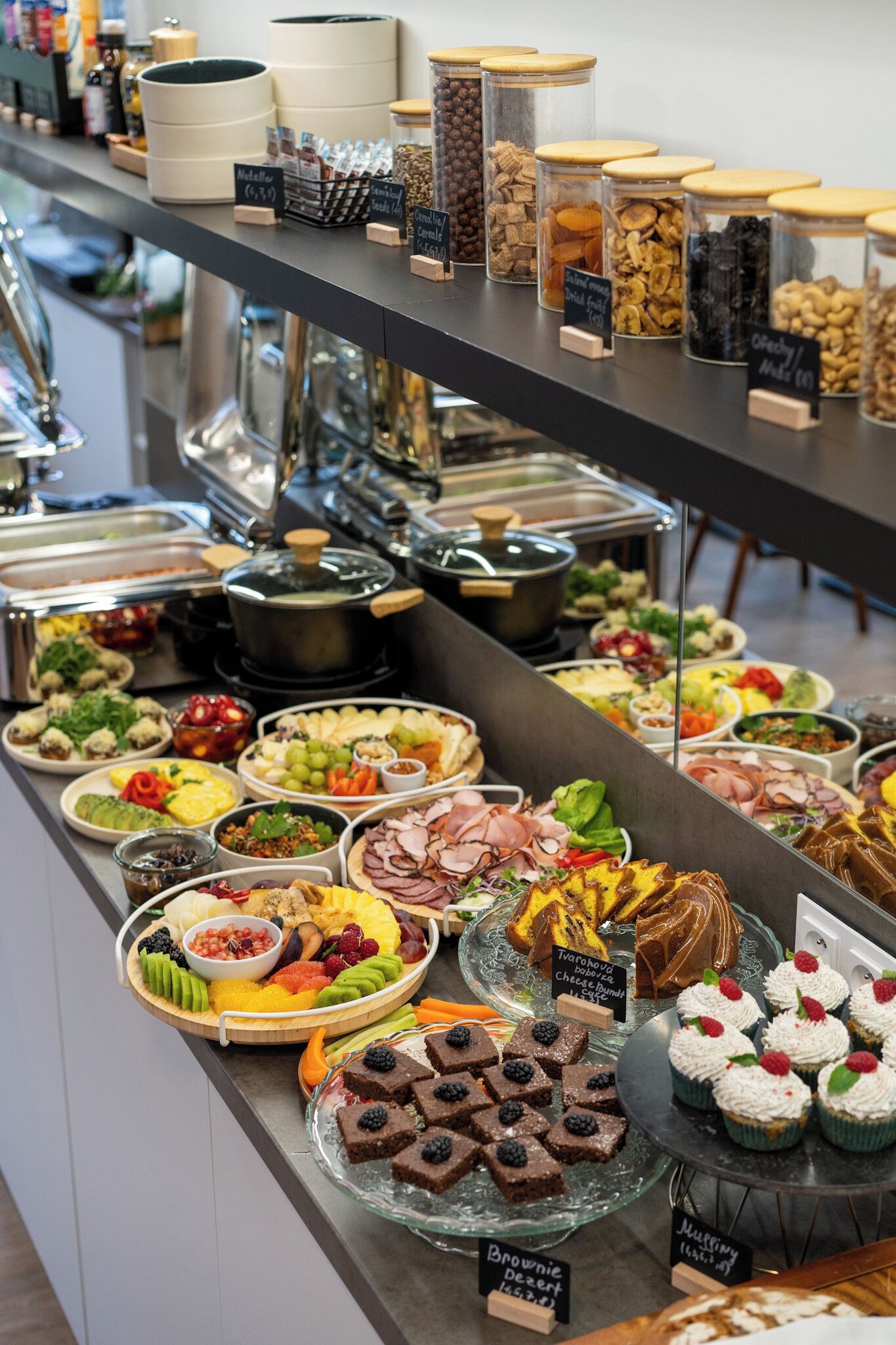 En buffé med ett varierat utbud av mat, inklusive frukt, nötter och desserter.