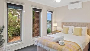A bedroom with a bed, a ceiling fan, and a window with a view of greenery. - Spacious Cowes Retreat with BBQ & Boat Parking (Cowes)
