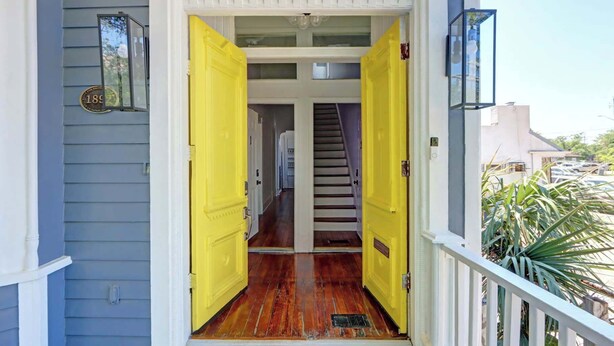 A wooden staircase leading to an upper floor, flanked by two open yellow doors. - Hall Manor Near Forsyth - Private Pool & Hot Tub! (Savannah)