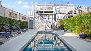 A swimming pool with a white deck, lounge chairs, and a staircase leading to a building with balconies. - Hall Manor Near Forsyth - Private Pool & Hot Tub! (Savannah)