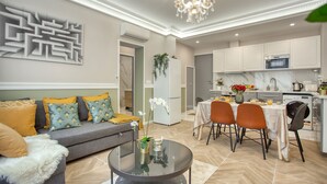Una sala de estar moderna con sofá, mesa de centro y comedor con sillas y una mesa.
