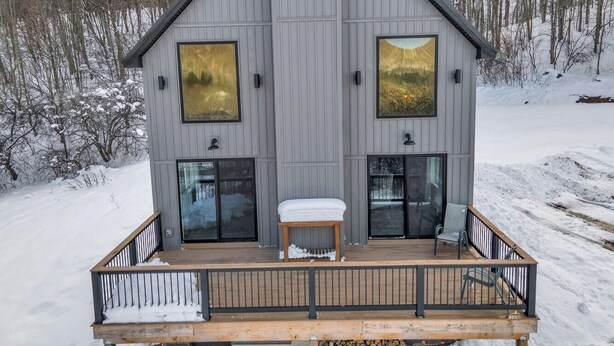A modern cabin with a wooden deck, large windows, and a snow-covered landscape. - New Build • Ellicottville Ski Chalet • Sleeps 8 (Ellicottville)