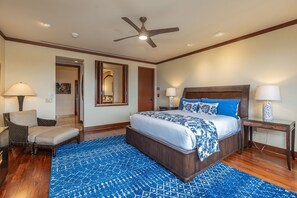 A bedroom with a large bed, a ceiling fan, a wooden floor, and a blue patterned rug. - Wailea Beach Villas M312 3 Bedroom Condo (Kihei)