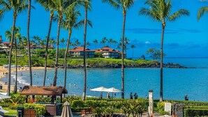 A beach resort with palm trees, a pool, and a view of the ocean. - Wailea Beach Villas M312 3 Bedroom Condo (Kihei)