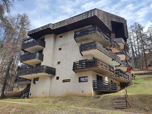 A multi-story building with balconies, a sign reading "Le Perche," and a natural, wooded backdrop. - 5th floor, balcony, tv, ski locker, 20m², Les Orres (Les Orres)