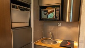 A compact kitchen with a stainless steel refrigerator, a microwave, and a sink with a wooden countertop. - 5th floor, balcony, tv, ski locker, 20m², Les Orres (Les Orres)