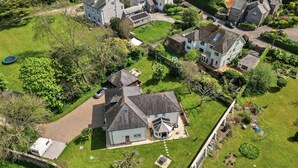 An aerial view of a residential area with houses, a swimming pool, and a well-maintained lawn. - Nicely Tucked Away Cottage (Millbrook)