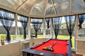 Enjoy a game of pool with a view of the surrounding landscape through large windows.