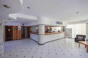 A lobby with a reception desk, a waiting area with a sofa, and a tiled floor. - Complejo Aloe - Pool - close to Maspalomas Beach (San Bartolomé de Tirajana)