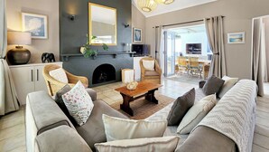 Sala de estar com lareira, sofá e área de jantar.
