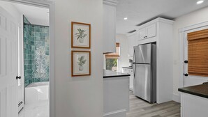 A modern kitchen with white cabinetry, a stainless steel refrigerator, and a wooden countertop. - Updated, Historic District, Walk to Waterfront. Pet-Friendly! Sleeps 12 (Warren)
