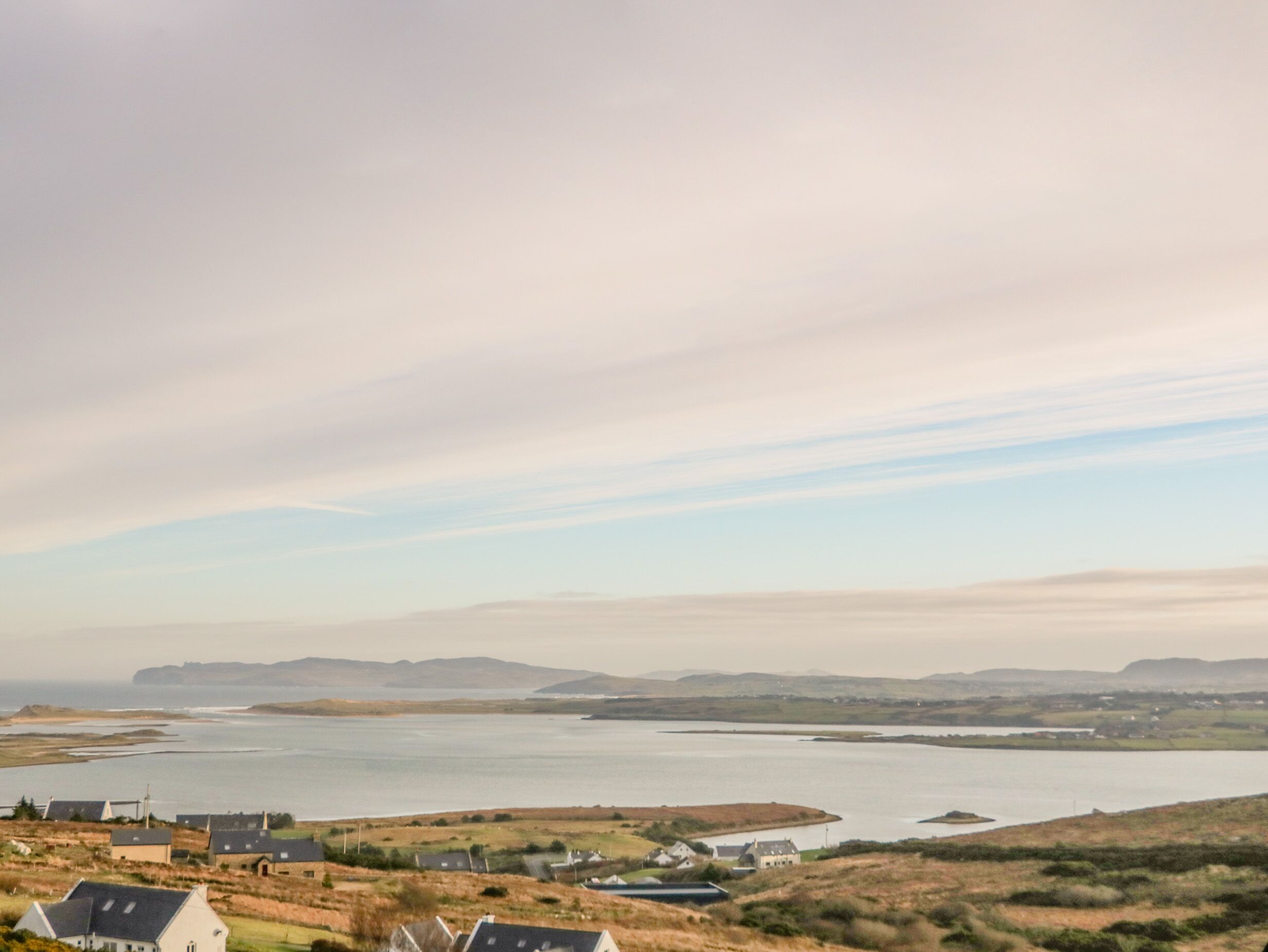 A coastal landscape with houses and a large body of water.