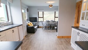 Una cocina moderna con comedor, sofá y televisor.