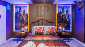 A bedroom with a large bed, two nightstands, a ceiling with intricate designs, and posters of Hogwarts castle. - Themed Townhome near Parks and Much More! (Davenport)