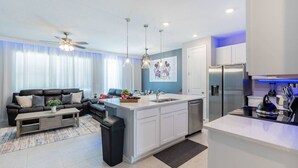 A modern apartment with a living room, kitchen, and dining area. - Themed Townhome near Parks and Much More! (Davenport)