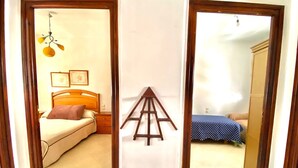 Una habitación con una cama, una escalera de madera y un edredón azul con lunares.