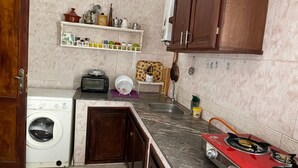 Una cocina con lavadora, estufa y armarios de madera.