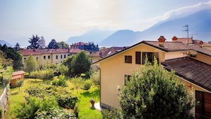 A residential area with houses, a well-maintained garden, and mountains in the background.